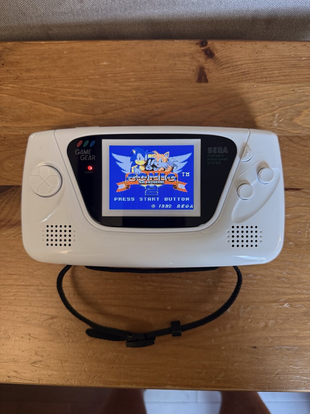 Modified white Sega Game Gear with an upgraded LCD running Sonic the Hedgehog 2